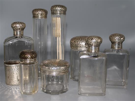 An Edwardian silver mounted glass hip flask and seven matching toilet bottles,